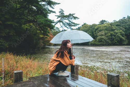 Portrait of woman crouching under umbrella photo