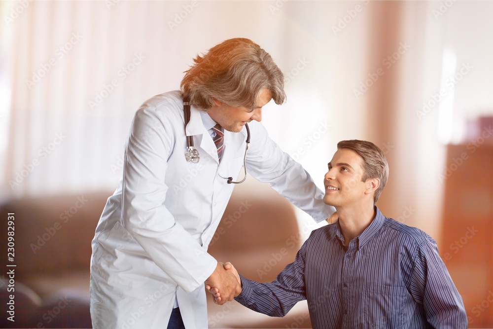 Obraz premium Friendly Senior doctor handshaking with young patient
