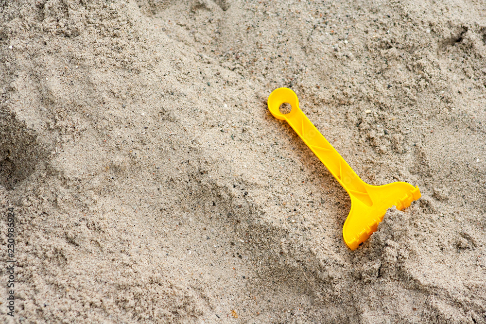 Bright plastic children's toys in the sand. Concept of beach recreation for children Bright plastic children's toys in the sand. Concept of beach recreation for children