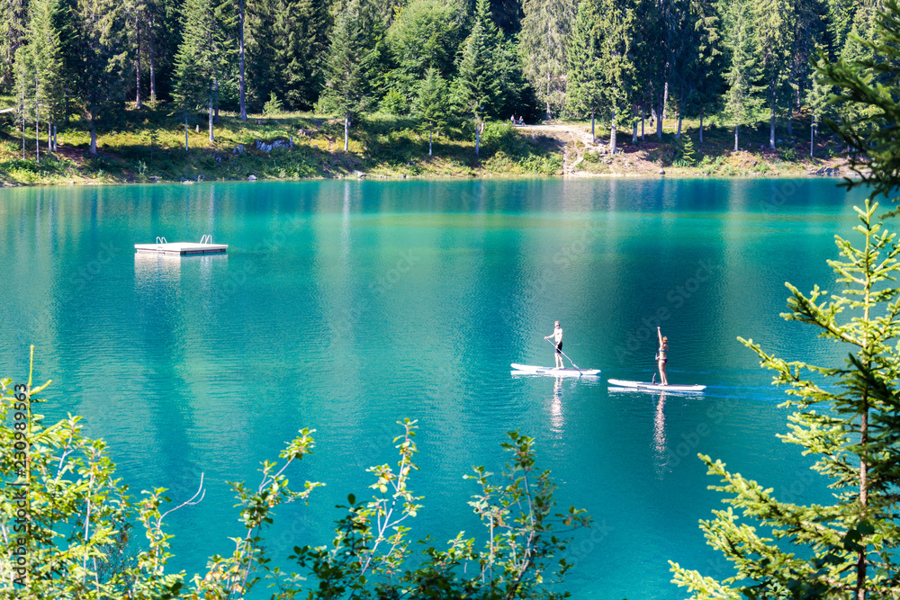 Foto de Young couple practise stand up paddling, Caumasee, Flims, District of Imboden, Canton of