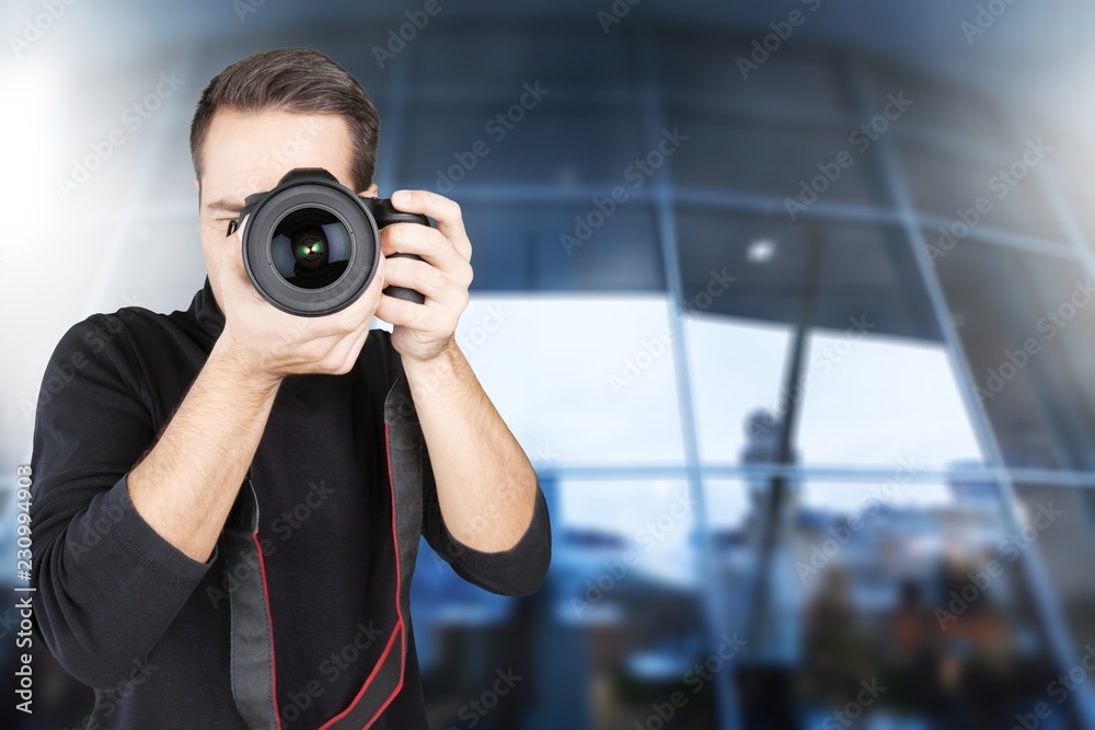 Male Photographer with Camera on grey background