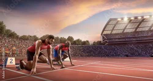 Obraz Sportowcy sprinterscy. Dwóch mężczyzn w sportowych ubraniach na linii startowej przygotowuje się do biegania na bieżni w profesjonalnym stadionie