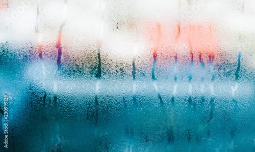 Water drops on blue glass, background photo of increased condensation, horizontal view, high quality