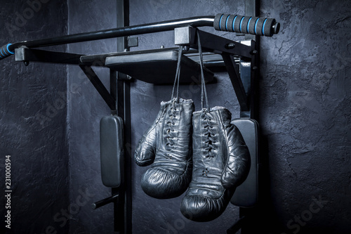 Old boxing gloves on a dark background.