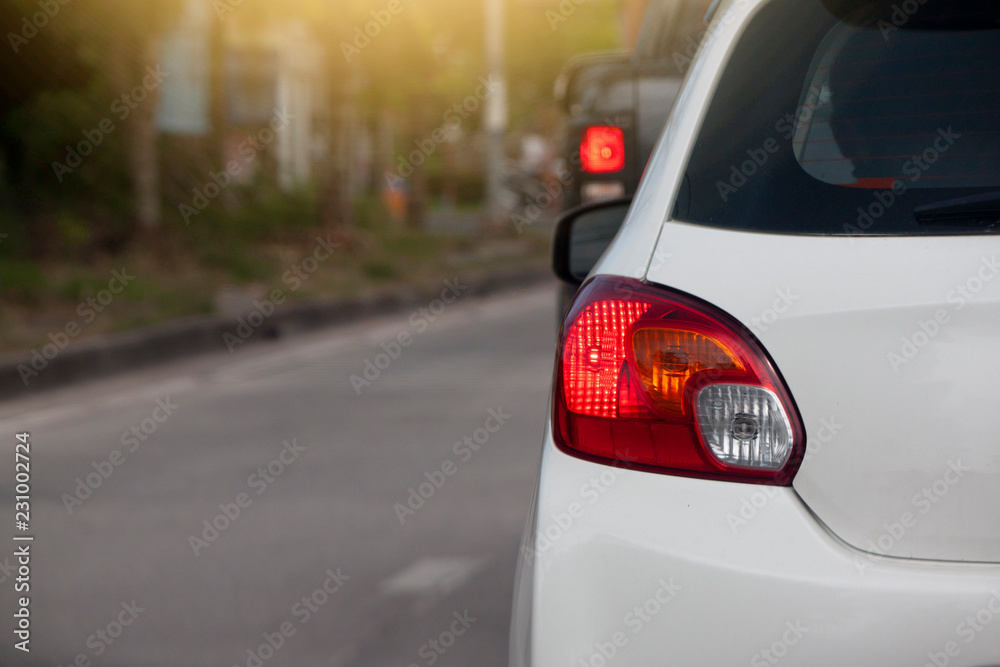 White car on the road stop by traffic light control in the junction.