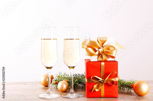 Beautiful christmas composition with two glasses of sparkling wine, decorations on wood textured table. New year's eve tradition to celebrate with champagne. Close up, copy space, background.