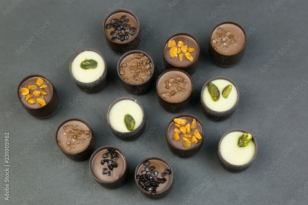 Chocolate candies on a colored background. Candies with different fillings laid out on a color table.