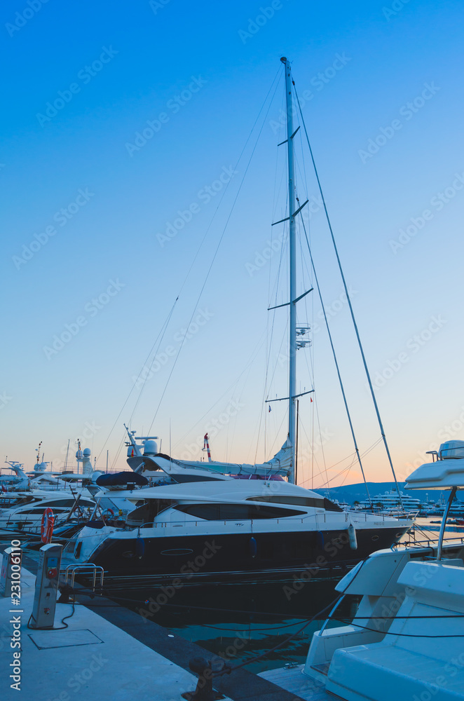 Fototapeta premium Boats and yachts moored in Adriatic port on background of mountains and sunset.