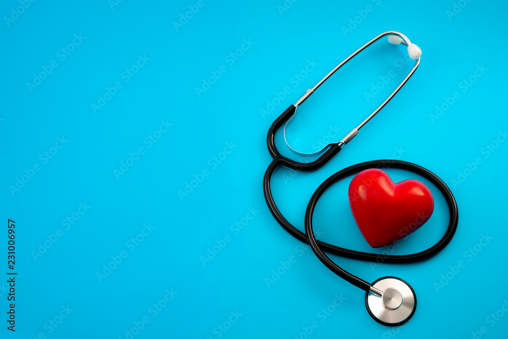 Yearly health check up, disease diagnosis medicine, healthcare and cardiology concept with a red heart and a stethoscope isolated on a hospital blue background with copy space