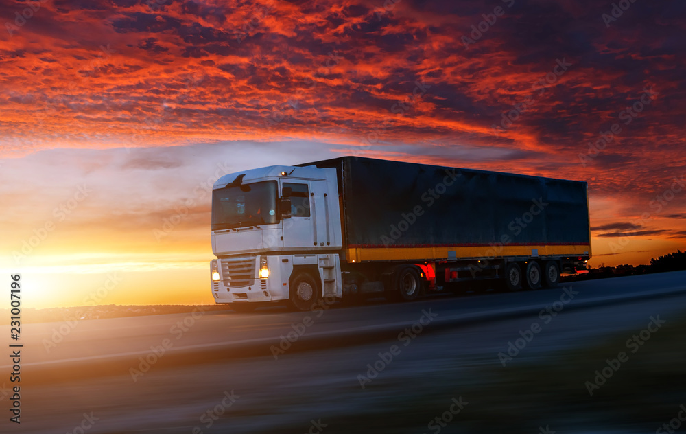 big White Truck on the Road in a Rural Landscape at Sunset. big White Truck on the Road in a Rural Landscape at Sunset.