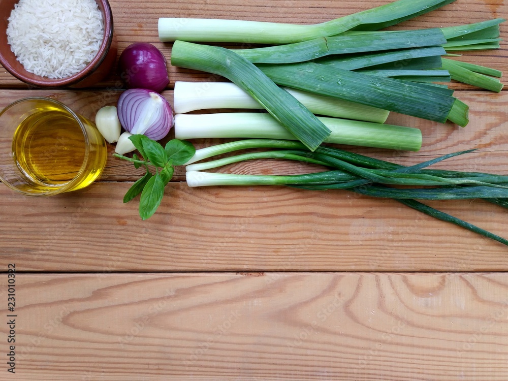 Leek,garlic,onion, rice, olive oil, on wooden background Leek,garlic,onion, rice, olive oil, on wooden background