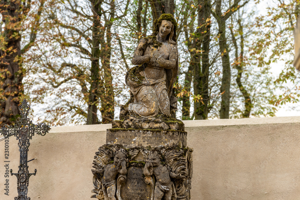 Statue couverte de mousse d'un cimetière en Moselle