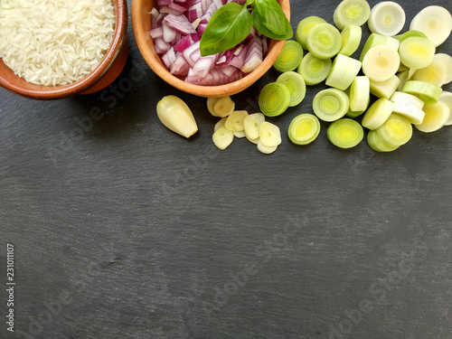 Fototapeta Naklejka Na Ścianę i Meble -  Ingredients on black background,rice,chopped onion,leek,garlic