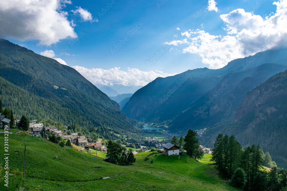landscape in alps with village, hills and lake