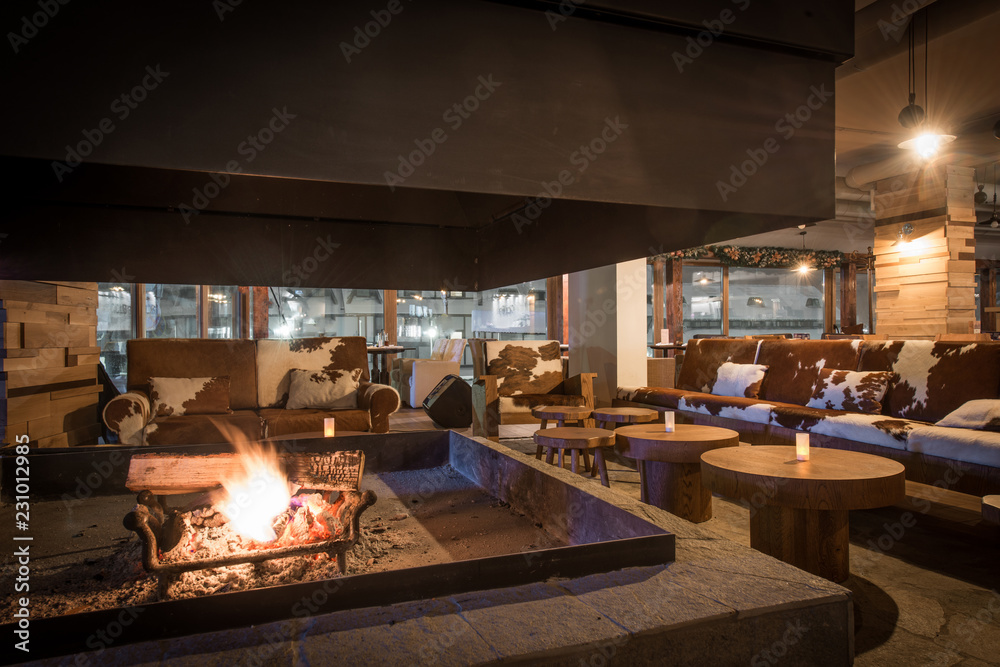Fireplace in restaurant decorated with cowhide furniture Fireplace in restaurant decorated with cowhide furniture
