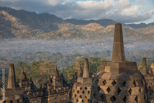 Fog covers the lower grounds with views from Borobudur Temple after sunrise in East Java, Indonesia