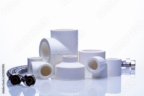 set of fittings for PVC pipes and reinforced water hose on a white background