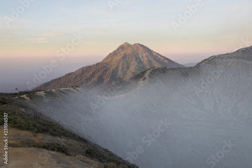 Sunrise hues with a smoke filled crater at Mount Ijen in East Java, Indonesia