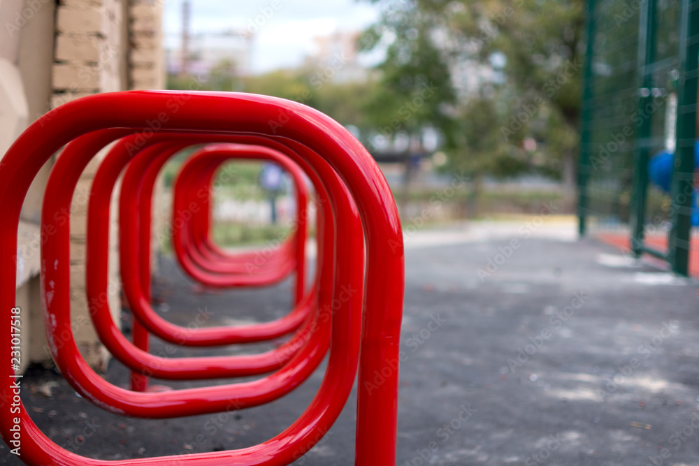 empty red bicycle parking near the wall empty red bicycle parking near the wall
