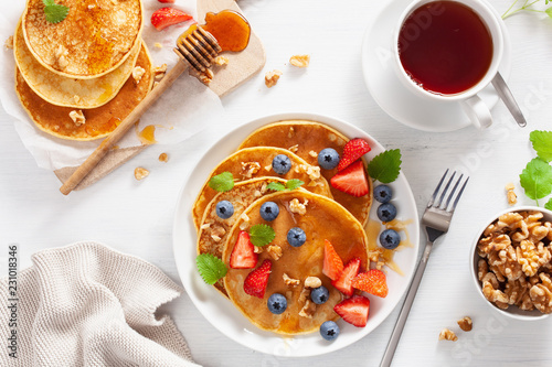 Obraz na płótnie pancakes with blueberry strawberry honey and nuts for breakfast w salonie