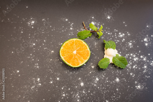 Slice of an Orange, creme and mint. Isolated over black background and white powder