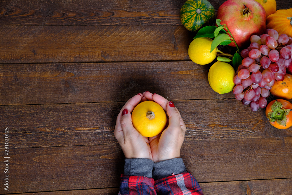 Φωτογραφία Woman hand with pumkin and fruits on a wooden background