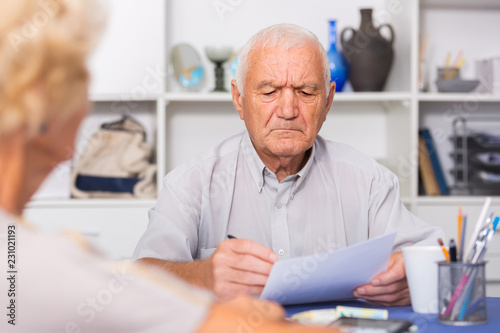 Upset senior man discussing with wife bills