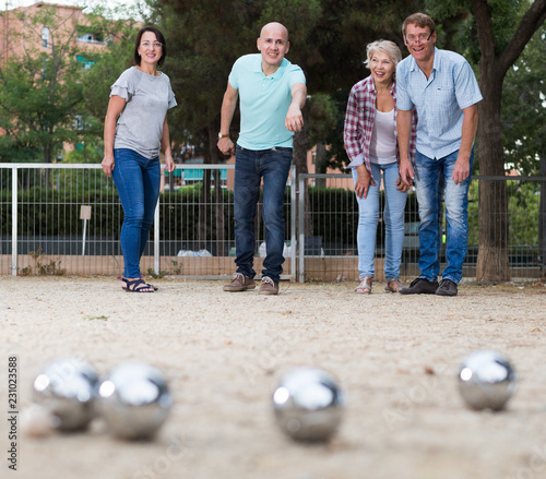 friendly mature couples playing petanque at leisure