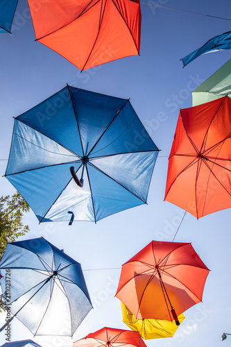 Colored umbrellas on the blue sky background