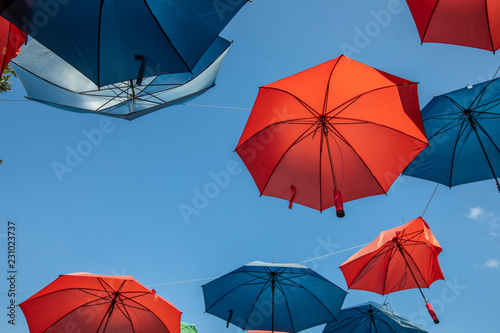 Colored umbrellas on the blue sky background