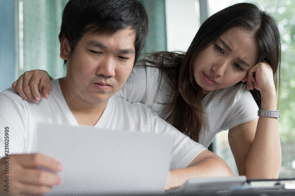Family financial crisis. Stressed young asian couple looking at issues notification from bank about late payment home loan credit. Family financial crisis. Stressed young asian couple looking at issues notification from bank about late payment home loan credit.