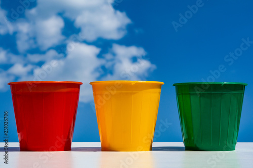 flower pots. three empty plastic cups against the sky and clouds. © Владимир Солдатов
