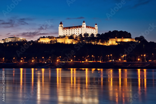 Bratislava castle at night, city lights reflection in Danube river