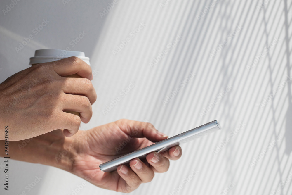 Hand holding SmartPhone with Sunlight entering the window Hand holding SmartPhone with Sunlight entering the window