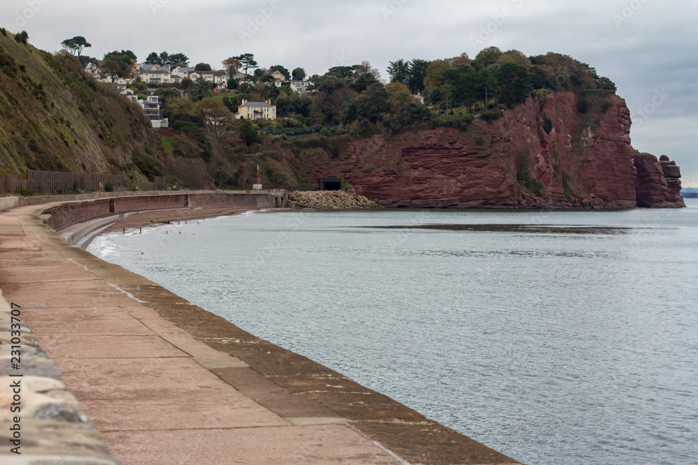 Cliffs surrounding Smuggler's Cove near the town of Teignmouth on the southern Devon coast in England as viewed from the sea wall below.
