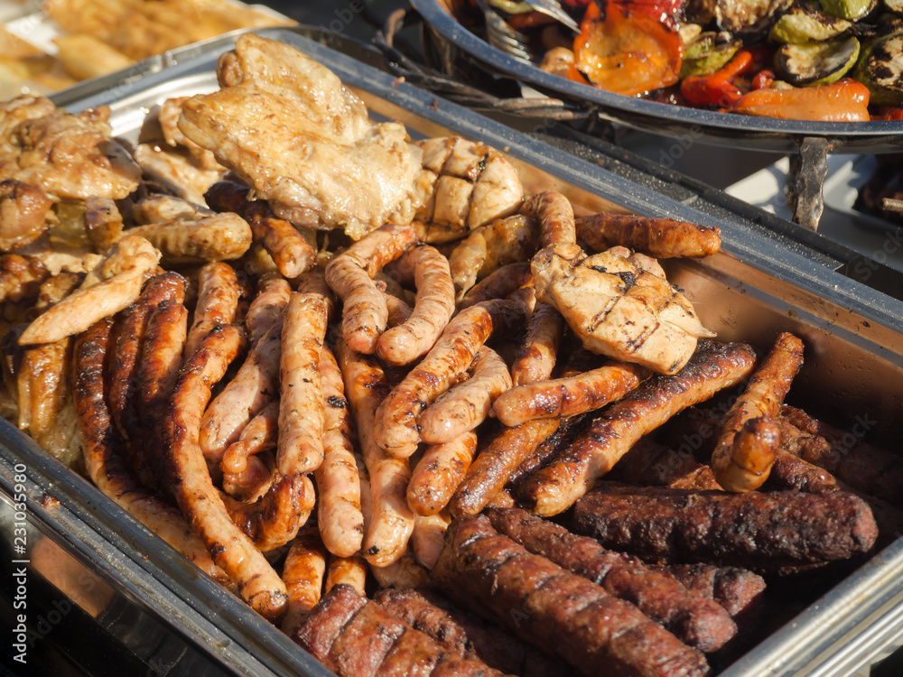 Various grilled sausages on a baking sheet. Street food.