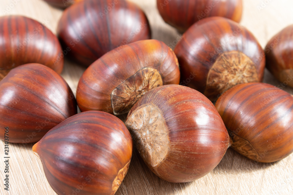 Close up of chestnuts on wooden background Close up of chestnuts on wooden background