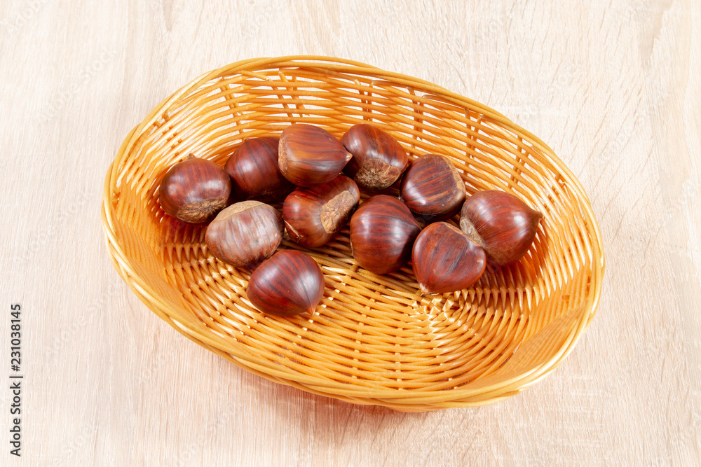 Obraz premium chestnuts in basket on wooden background