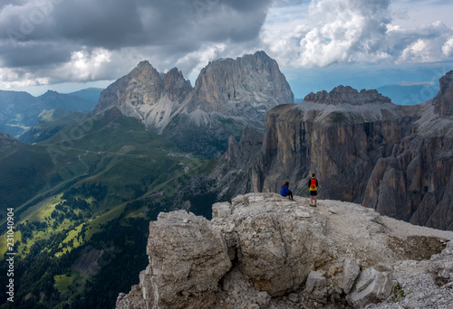 Two hikers taking a rest on top of Sass Pordoi in the Italian Dolomite mountains