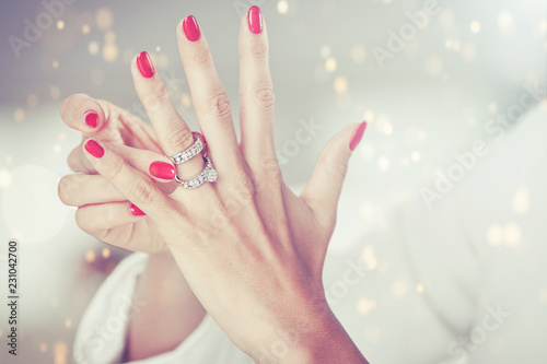 female hands with red nails and elegant diamond rings.