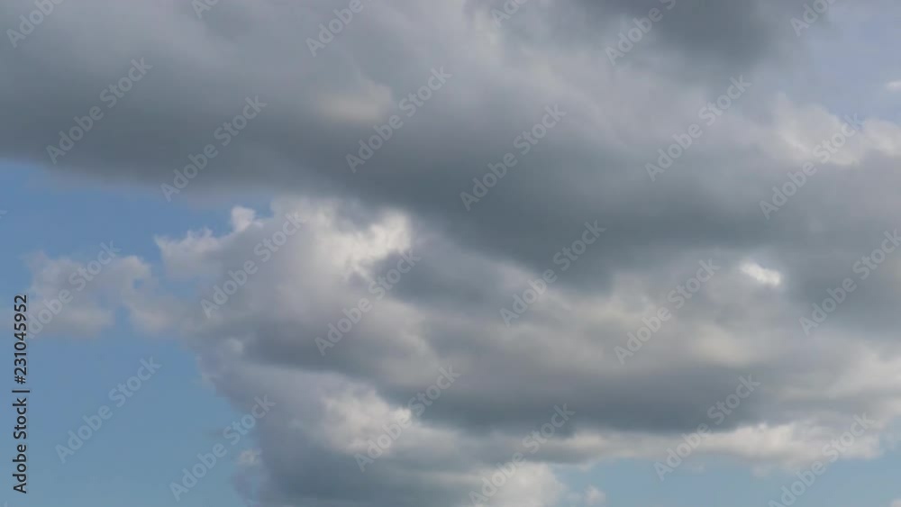 White and gray puffy cumulus clouds on blue sky in bright sunny day. Time-lapse footage. White and gray puffy cumulus clouds on blue sky in bright sunny day. Time-lapse footage.