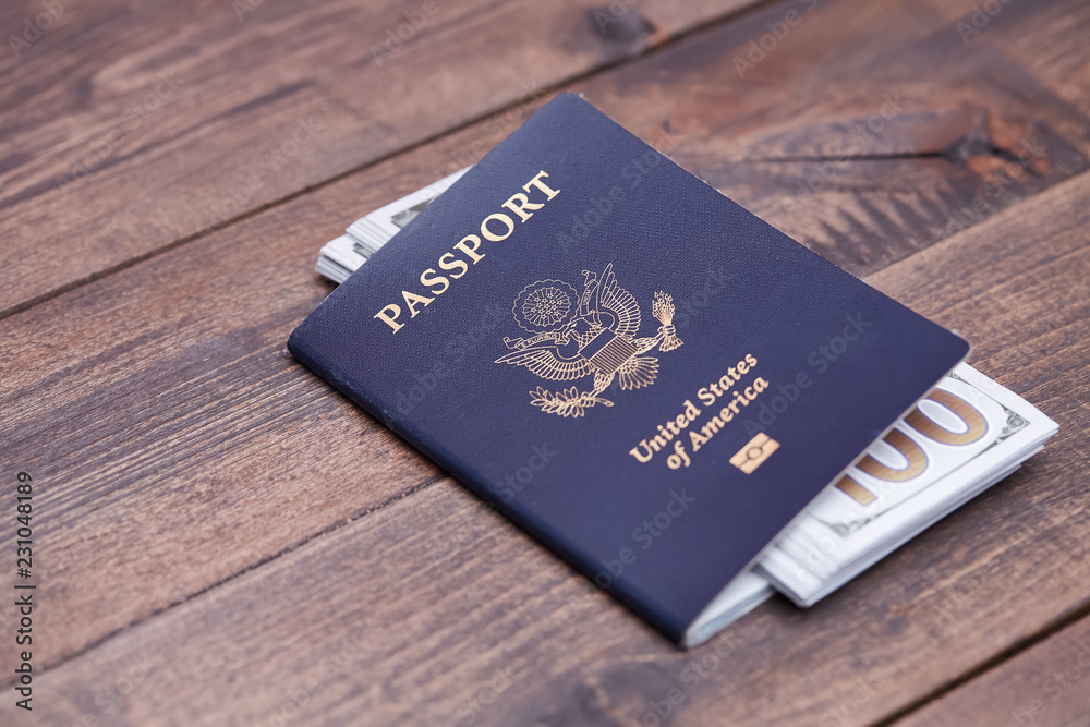 Passport of United States of American. Traveling passport. closeup of american passport and money on a wooden surface. travel concept. Passport of United States of American. Traveling passport. closeup of american passport and money on a wooden surface. travel concept.
