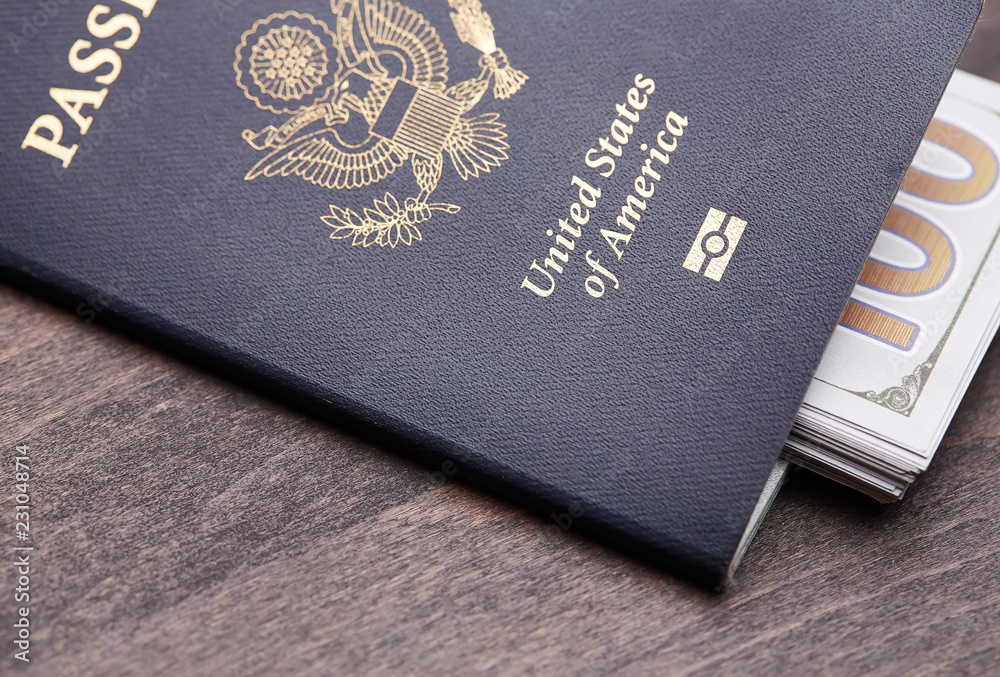 Passport of United States of American. Traveling passport. closeup of an american passport and money on a wooden table for a travel concept. Passport of United States of American. Traveling passport. closeup of an american passport and money on a wooden table for a travel concept.