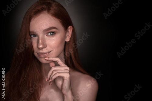Thinking dreaming redhead girl woman with healthy glow wet skin posing isolated over black wall background looking aside to empty copyspace.
