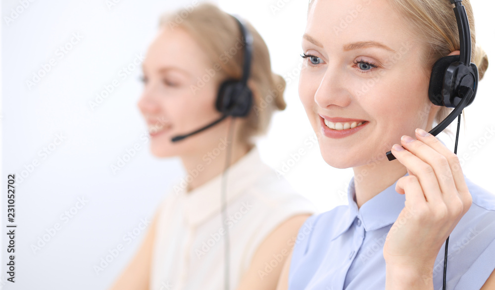 Bright call center office. Two blonde women in a headset Bright call center office. Two blonde women in a headset