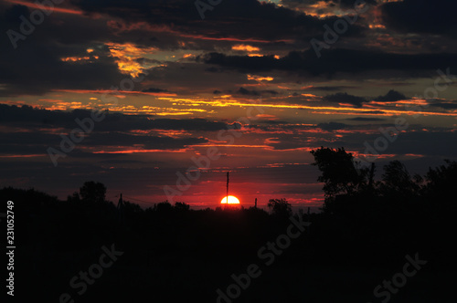 Beautiful sunrise in the village with clouds and orange sky