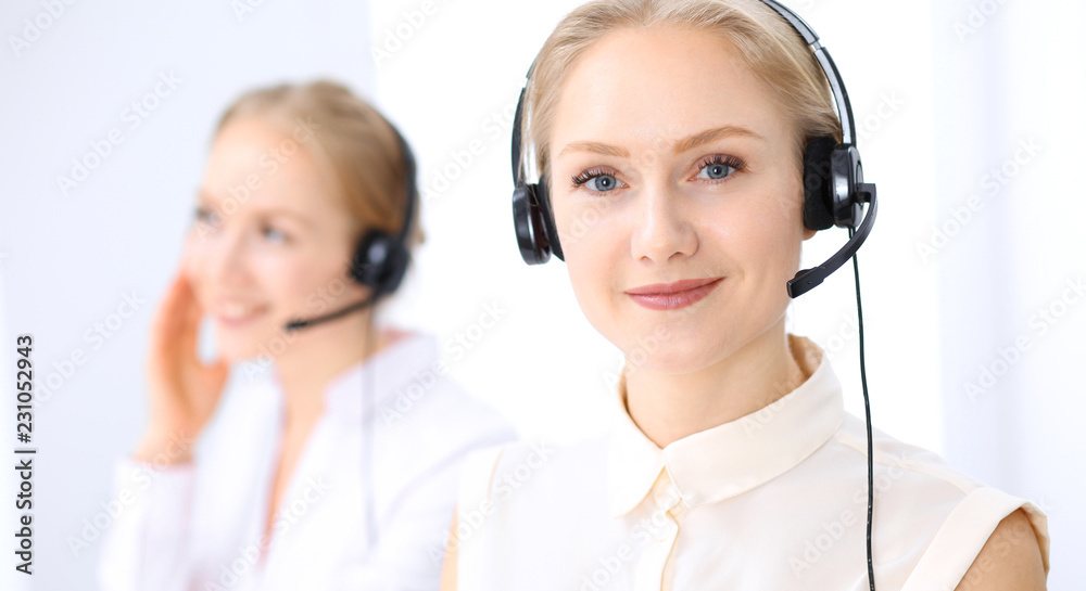 Bright call center office. Two blonde women in a headset Bright call center office. Two blonde women in a headset