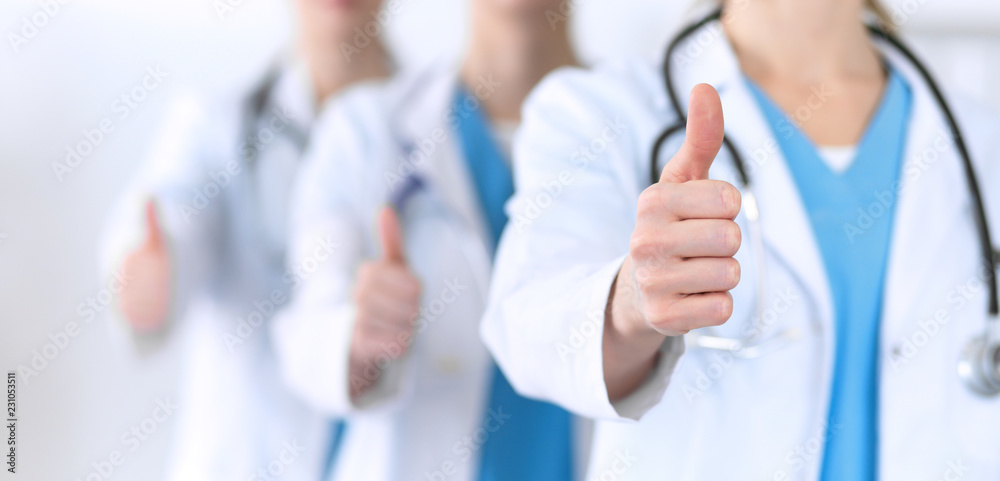 Groupe of medicine doctors show OK sign with thumb up close up. Success and high level service in health care, best treatment and customer loyalty and physical concept. Copy space for advertisement Groupe of medicine doctors show OK sign with thumb up close up. Success and high level service in health care, best treatment and customer loyalty and physical concept. Copy space for advertisement