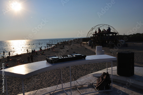 DJ plays music on the beach at sunset