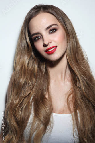 Young beautiful girl with long hair and red lipstick